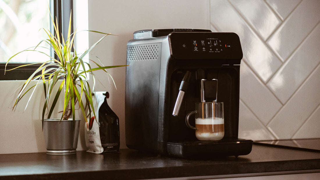  machine espresso automatique noire sur un comptoir avec un sac de café et une plante verte