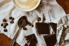  chocolat noir et grains de café sur linge blanc avec un café